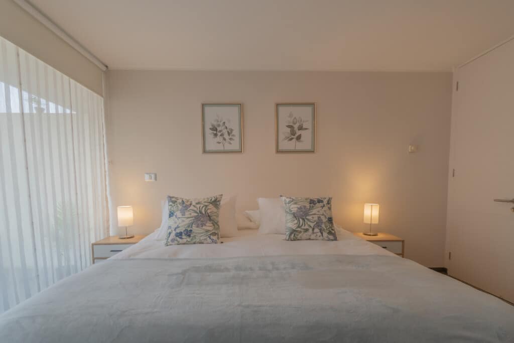 Dormitorio con vista y decoracion floral en Santiago Apartments